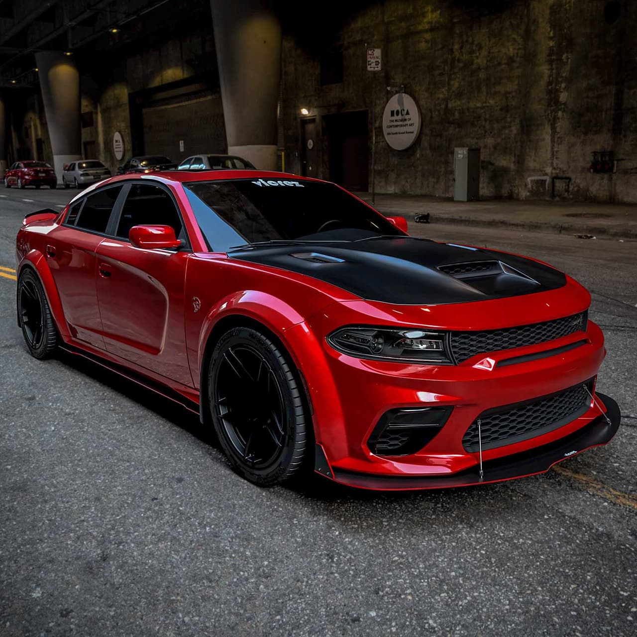 Red Dodge Charger with a Vicrez front splitter and support rods
